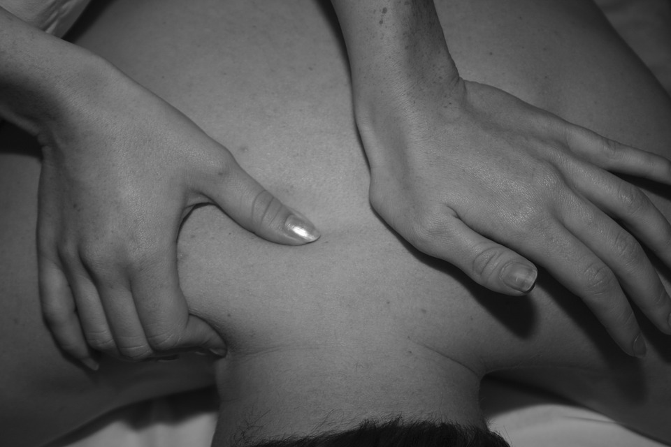 Grayscale image of person getting a back massage - Delayed Onset Muscle Soreness (DOMS) blog post