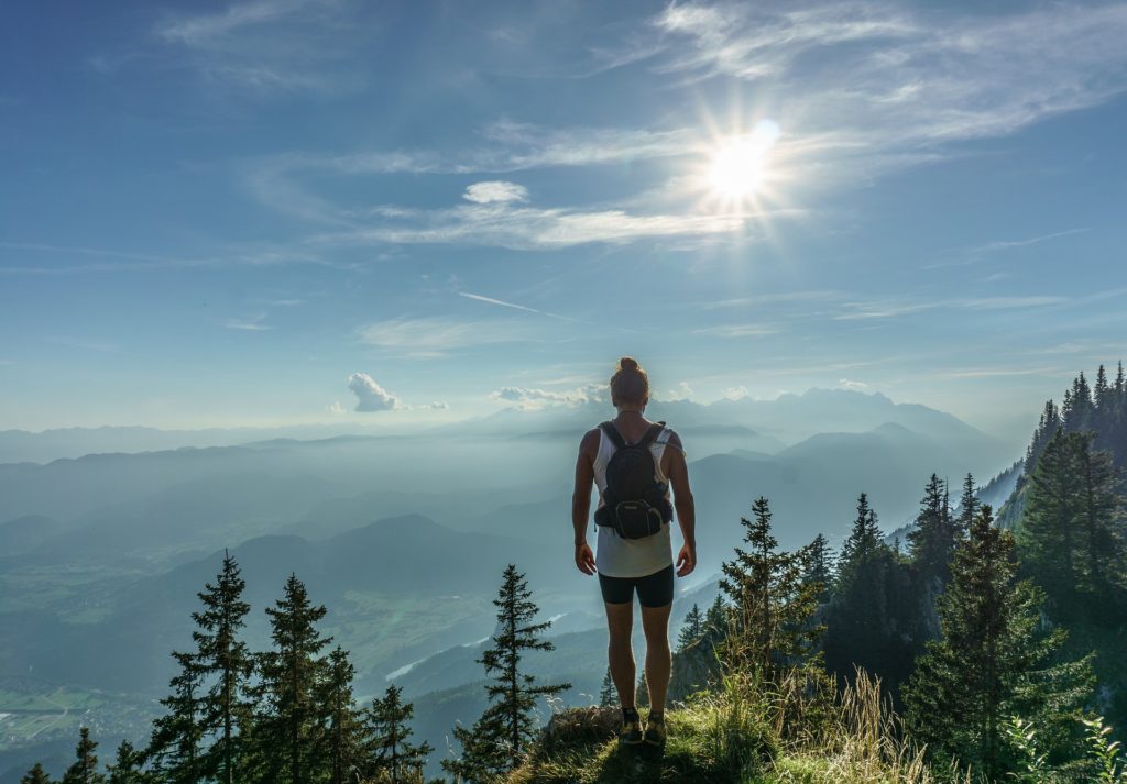 Woman with backpack on mountain - 7 ways to live a healthier lifestyle blog post