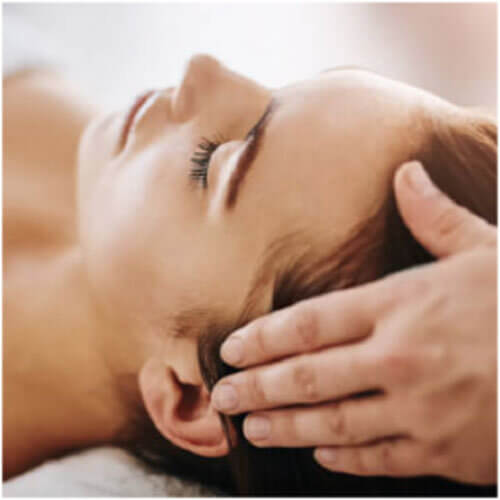 Woman laying on back getting a head massage